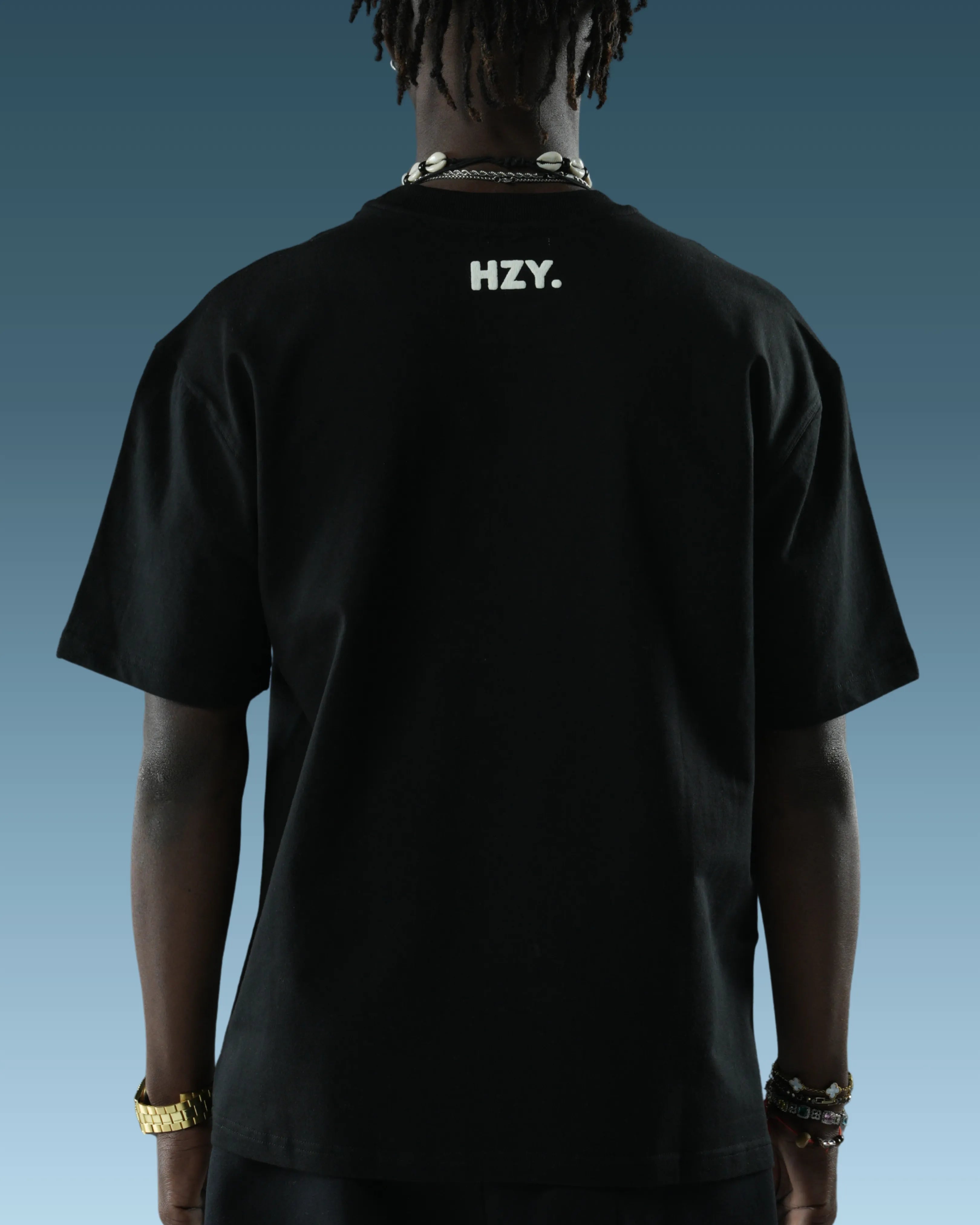 Person wearing a black streetwear t-shirt with 'HZY.'